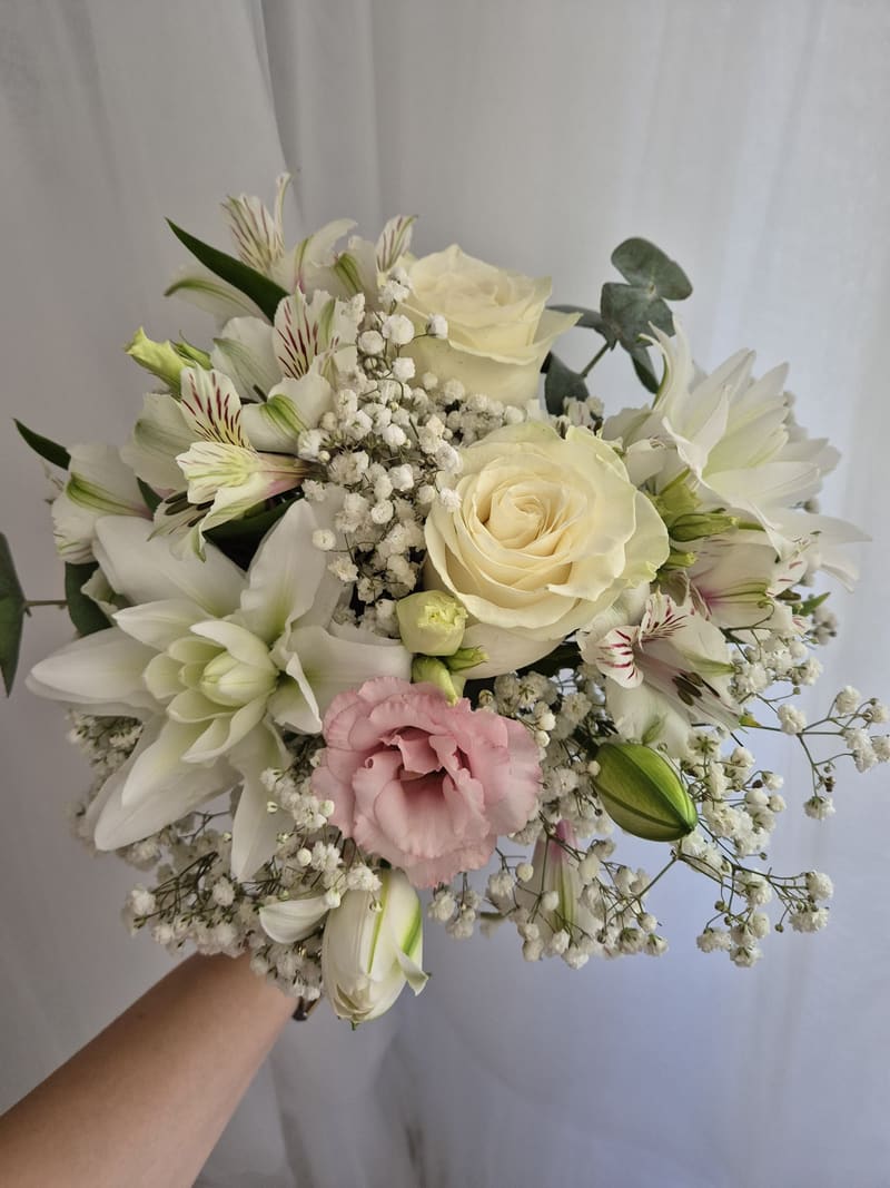 Buchet alb și roz cu trandafiri, lisianthus și floarea-miresei, ținut în mână