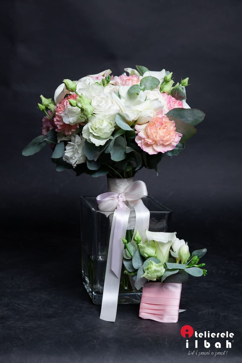Buchet pastel și cocardă asortată, fotografiate pe fundal negru